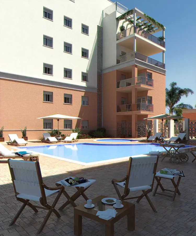 Zona de piscina del residencial Regata con fachada de ladrillo y terrazas ajardinadas