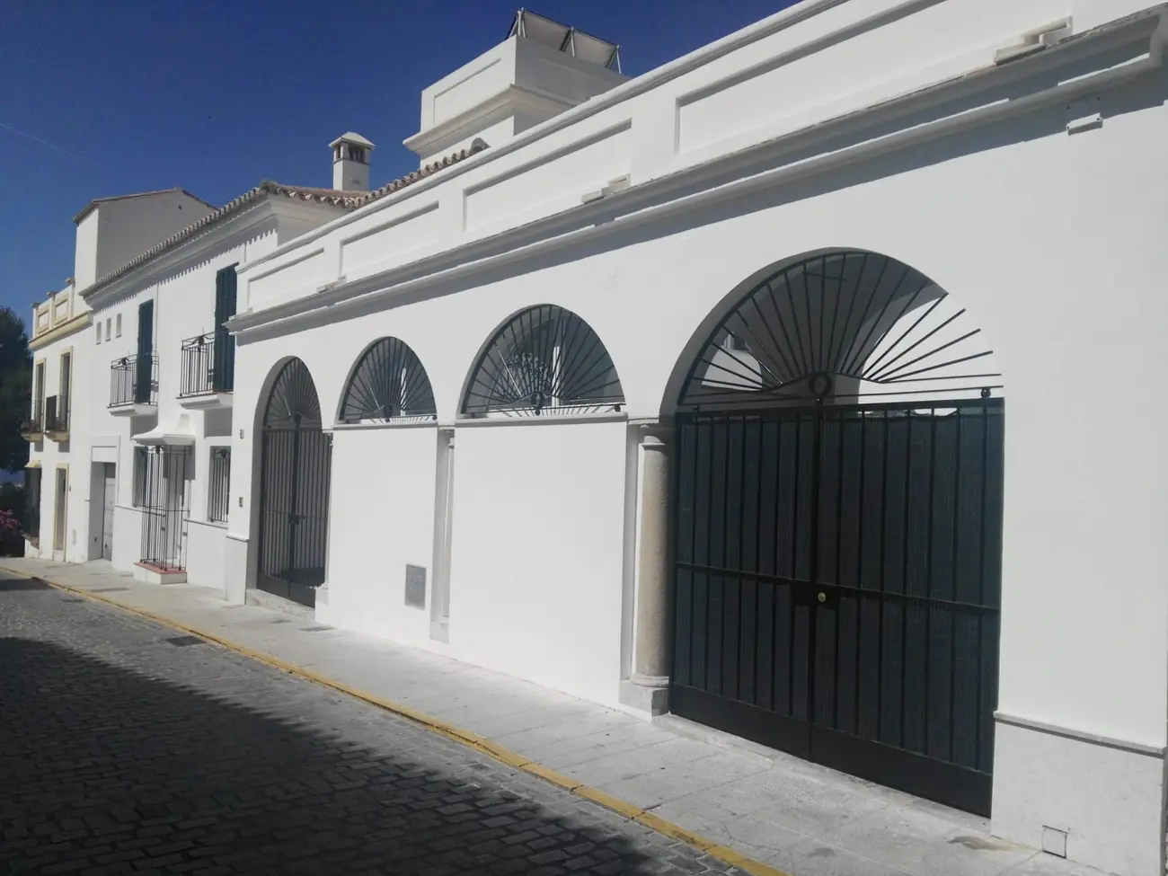 El edificio rehabilitado, con fachada encalada y arcos de cerrajería recuperados